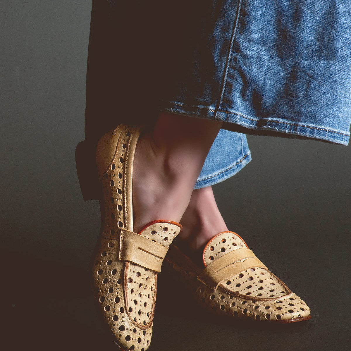 Person wearing tan Cornflower slip-on shoes handcrafted in Italy by Bed Stu and blue denim pants.