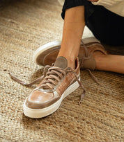 Bed|Stü Cosmo tan leather sneakers with a white sole and contrast stitching, worn on a person’s feet.