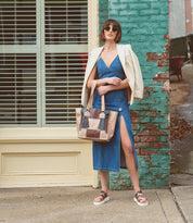 A woman wearing a Bed Stu denim dress and Bed Stu strappy upper sandals.