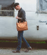 A man carrying a Depp tan leather briefcase by Bed Stu for organization.