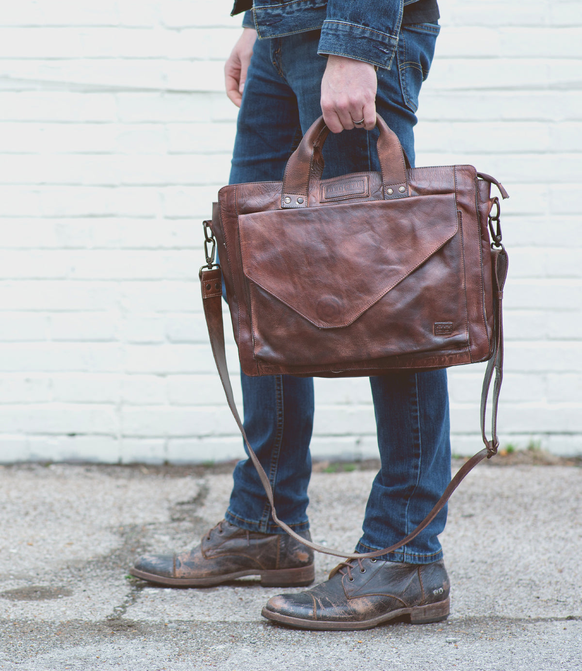 A man holding a Depp brown leather briefcase symbolizing organization by Bed Stu.