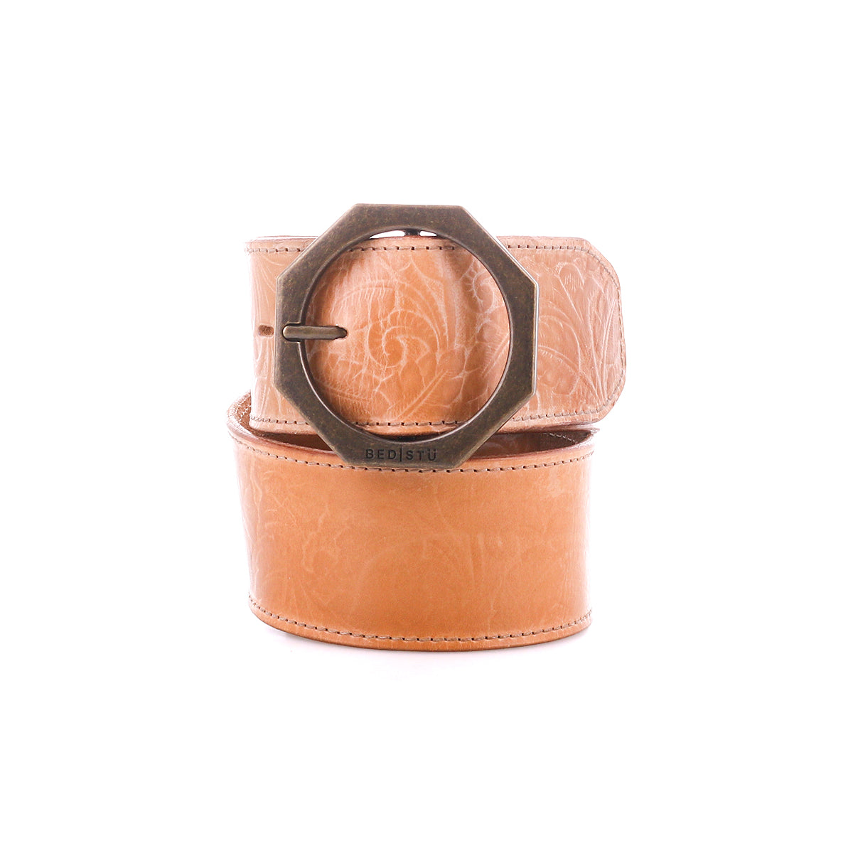 Tan Bed Stu Dreampath EM genuine leather belt featuring an embossed floral pattern and a bold octagon metal buckle, shown coiled on a white background.
