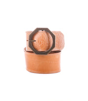 Tan Bed Stu Dreampath EM genuine leather belt featuring an embossed floral pattern and a bold octagon metal buckle, shown coiled on a white background.