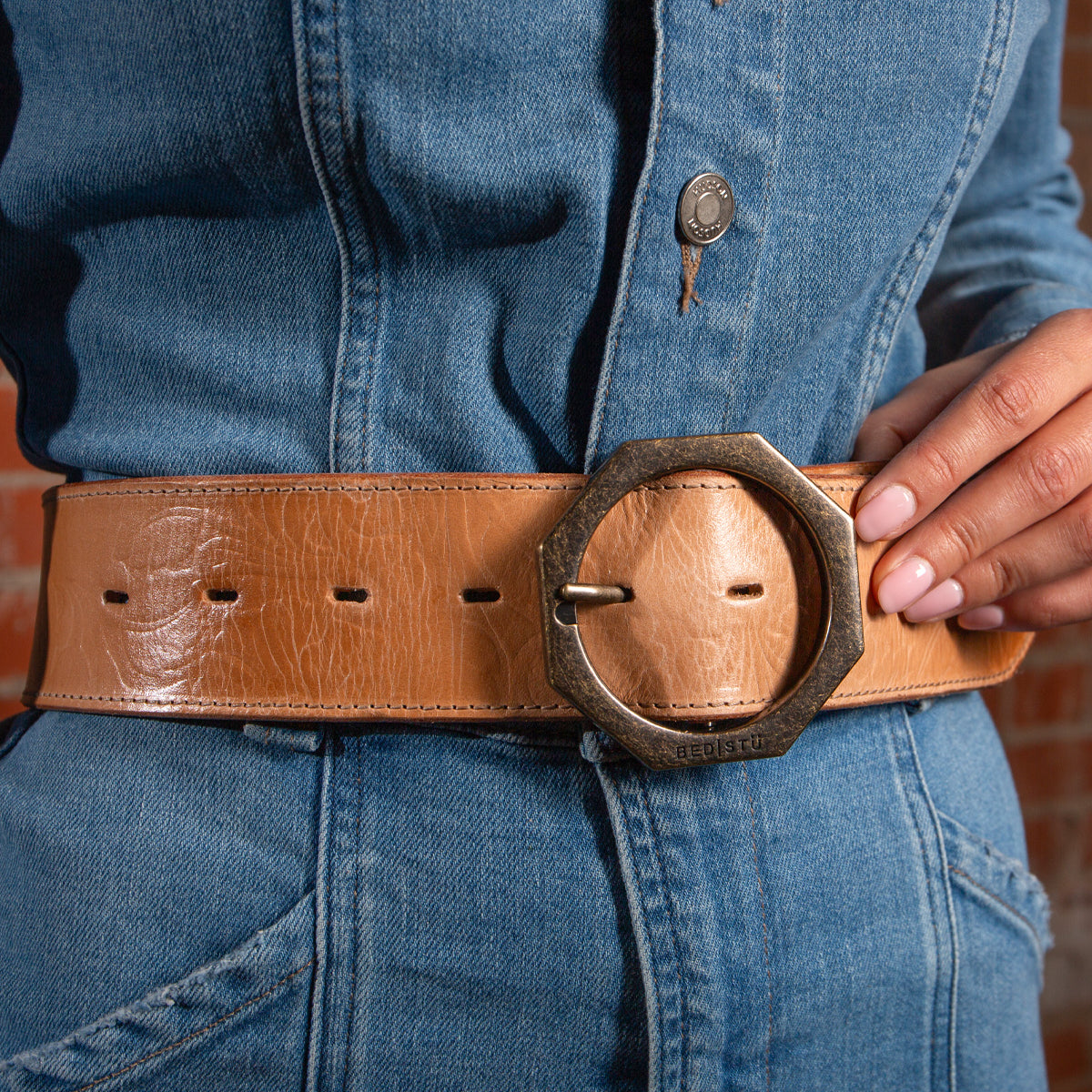A person wearing a blue denim outfit with a modern style Bed Stu Dreampath EM genuine leather belt featuring a large octagon metal buckle.