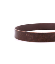 The Drifter brown leather belt from Bed Stu is elegantly displayed in a circular shape against a pristine white background, exuding a dapper appeal.