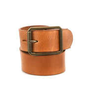 The Bed Stu Drifter is a tan leather belt with a brass rectangular buckle, coiled neatly buckle-forward—an ideal weekend accessory for any wardrobe.