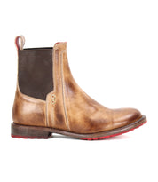 The Bed Stu Ethic is a brown Chelsea boot made from vegetable-tanned leather, with an elastic side panel, back pull tab, and bold red Vibram sole—shown in a side view.