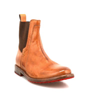 The Bed Stu Ethic is a tan vegetable-tanned leather Chelsea boot with a brown elastic side panel, back pull tab, and a red Vibram sole.