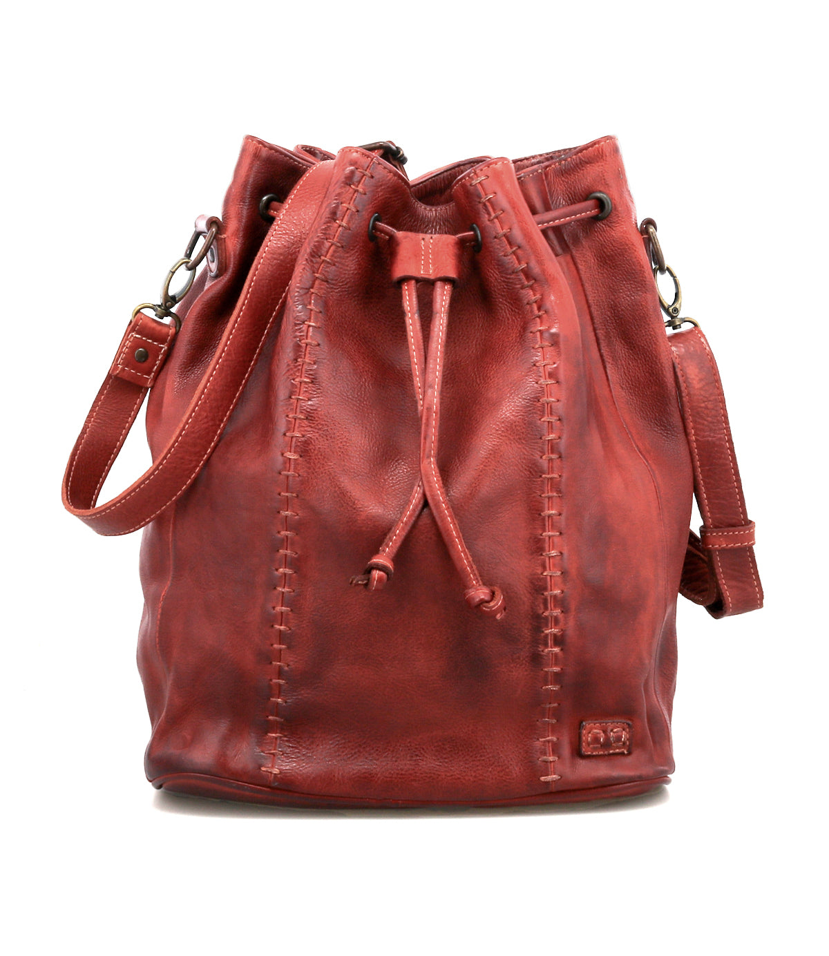 The Bed Stu Eve is a red leather bucket bag with a drawstring cinch, visible side stitching, and a shoulder strap that can also be worn crossbody.