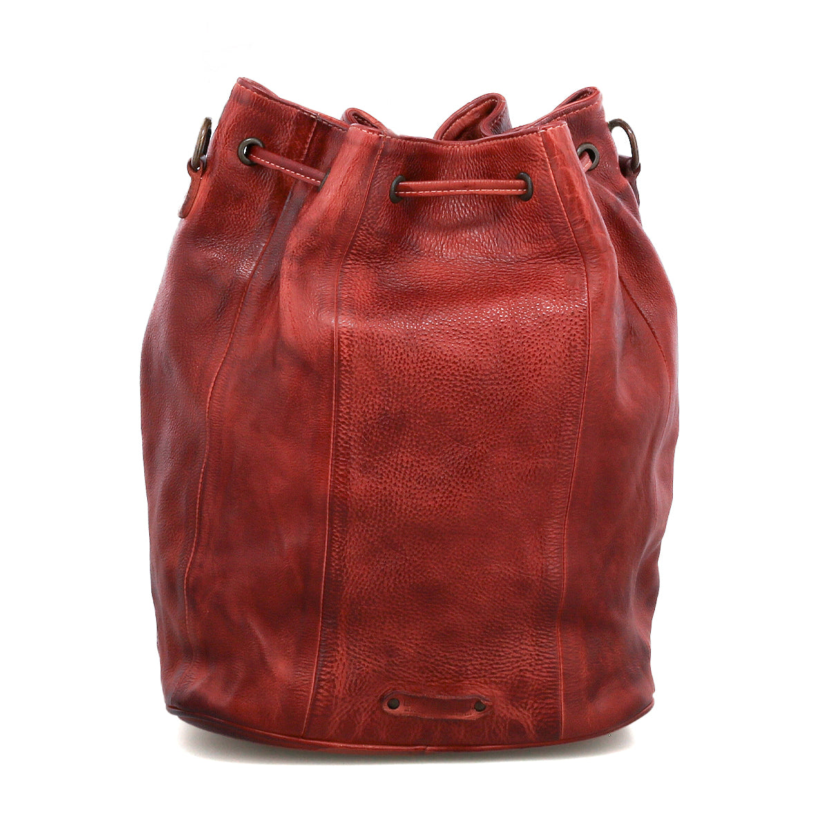 The Bed Stu Eve is a red leather bucket bag with a drawstring cinch and grommets, featuring a slightly textured finish and standing upright on a white background.