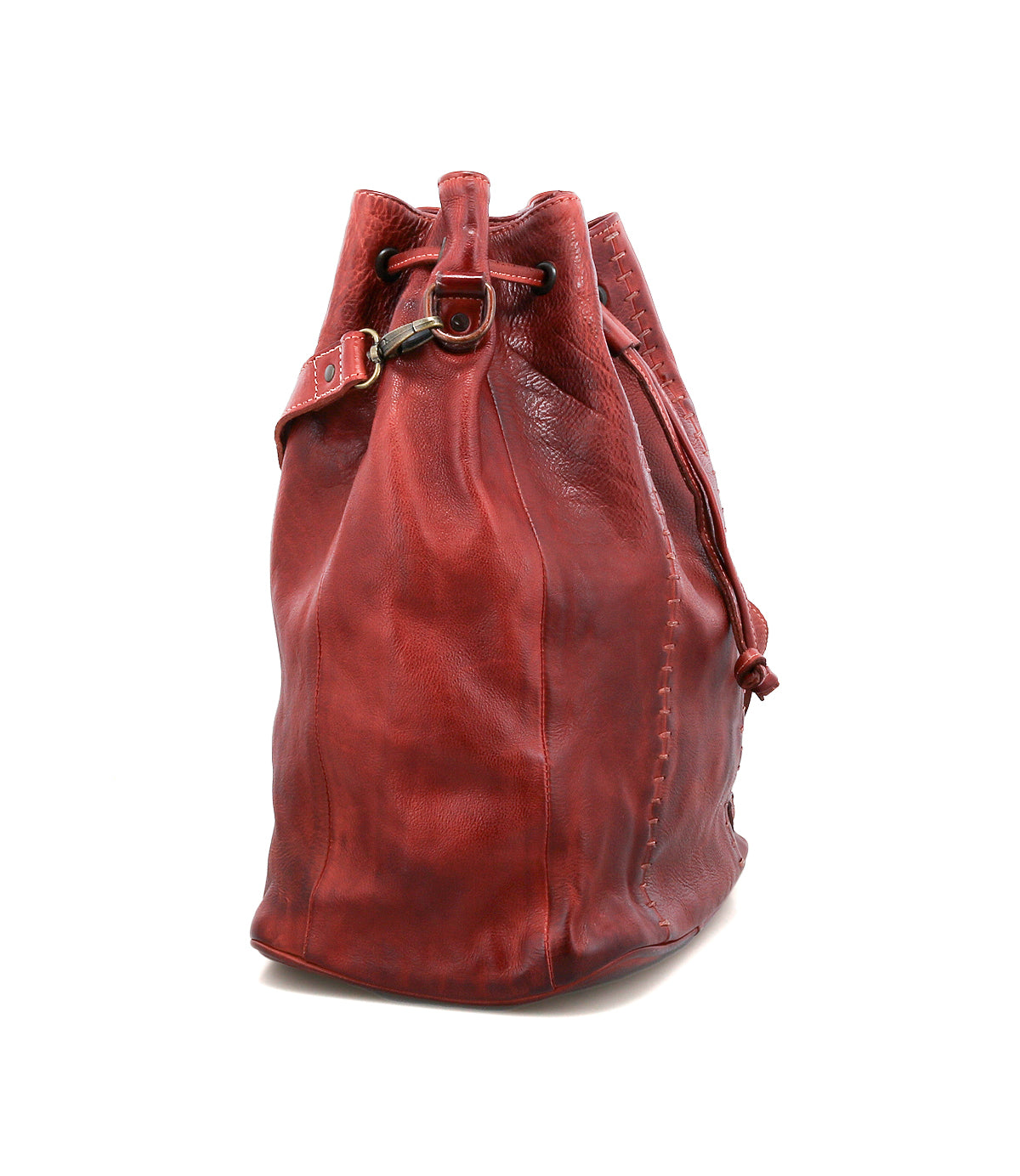 The Bed Stu Eve is a red leather bucket bag with a crossbody strap and drawstring closure, pictured from the side against a plain white background.
