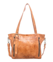 The Bed Stu Explicit LTC is a tan, seasoned leather tote with two shoulder straps, a detachable crossbody strap, front zippers, and a small buckle strap—perfect for adding rustic appeal to your everyday bag collection.