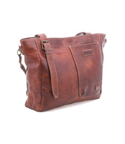 The Bed Stu Explicit LTC is a brown leather rustic bag with a front pocket, adjustable strap, and visible stitching, shown against a white background.