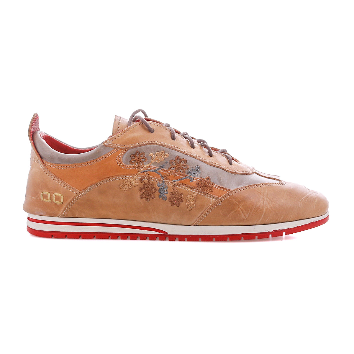 The Bed|Stü Extravagant sneaker features tan leather, a lace-up silhouette, floral embroidery on the side, a striking red sole, and red interior lining, displayed in a side profile view against a white background.