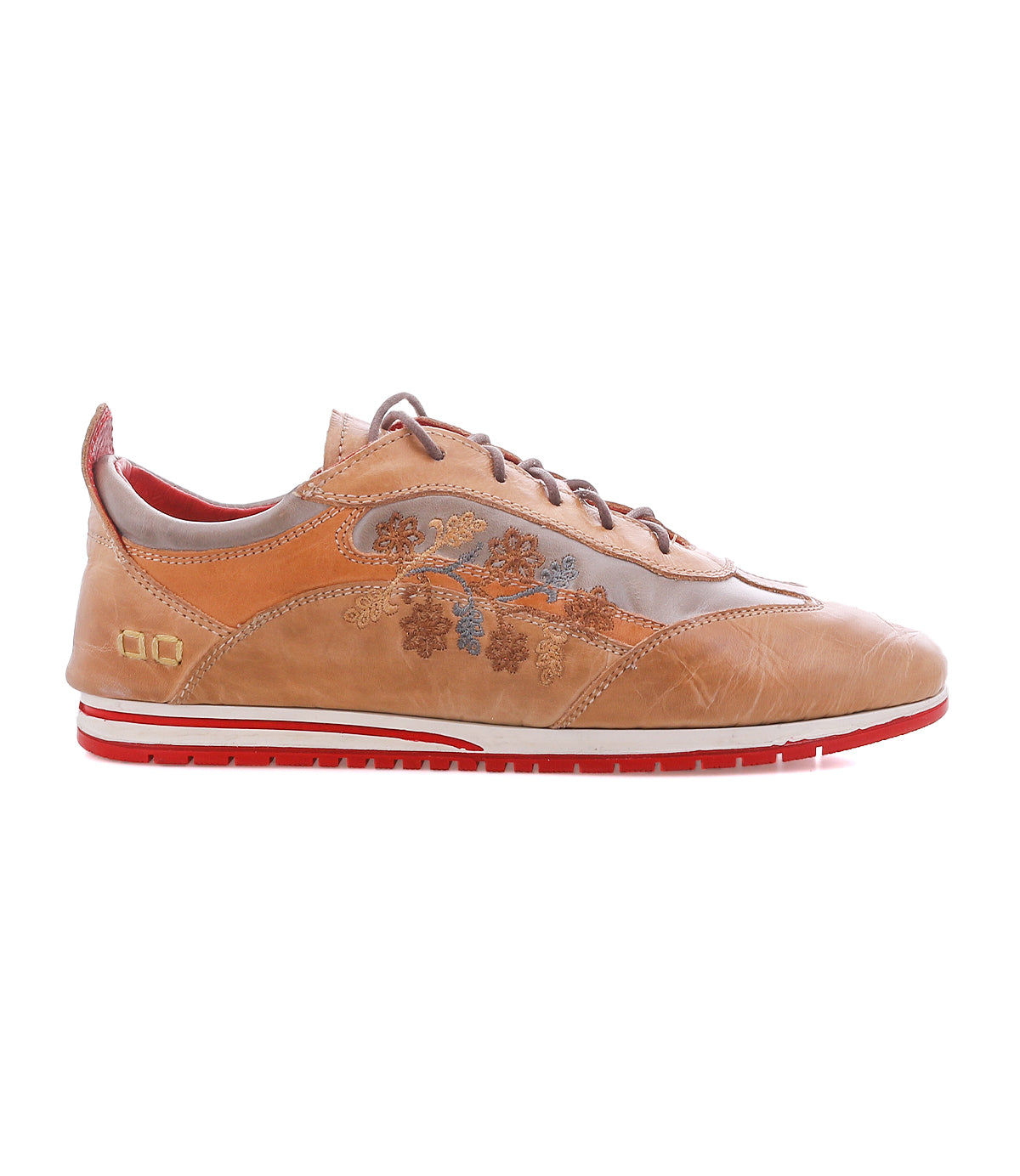 The Bed|Stü Extravagant sneaker features tan leather, a lace-up silhouette, floral embroidery on the side, a striking red sole, and red interior lining, displayed in a side profile view against a white background.