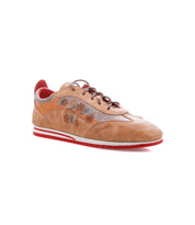The Bed|Stü Extravagant is a tan leather sneaker with floral embroidery, showcasing a classic lace-up silhouette, brown laces, a vibrant red interior, and a distinctive white and red rubber sole—perfect for everyday wear.