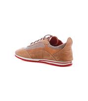 The Bed|Stü Extravagant sneaker is crafted in tan leather with brown and red accents, shown from behind at an angle to highlight its classic everyday style, featuring a lace-up silhouette, coordinating laces, and a distinctive red rubber sole.