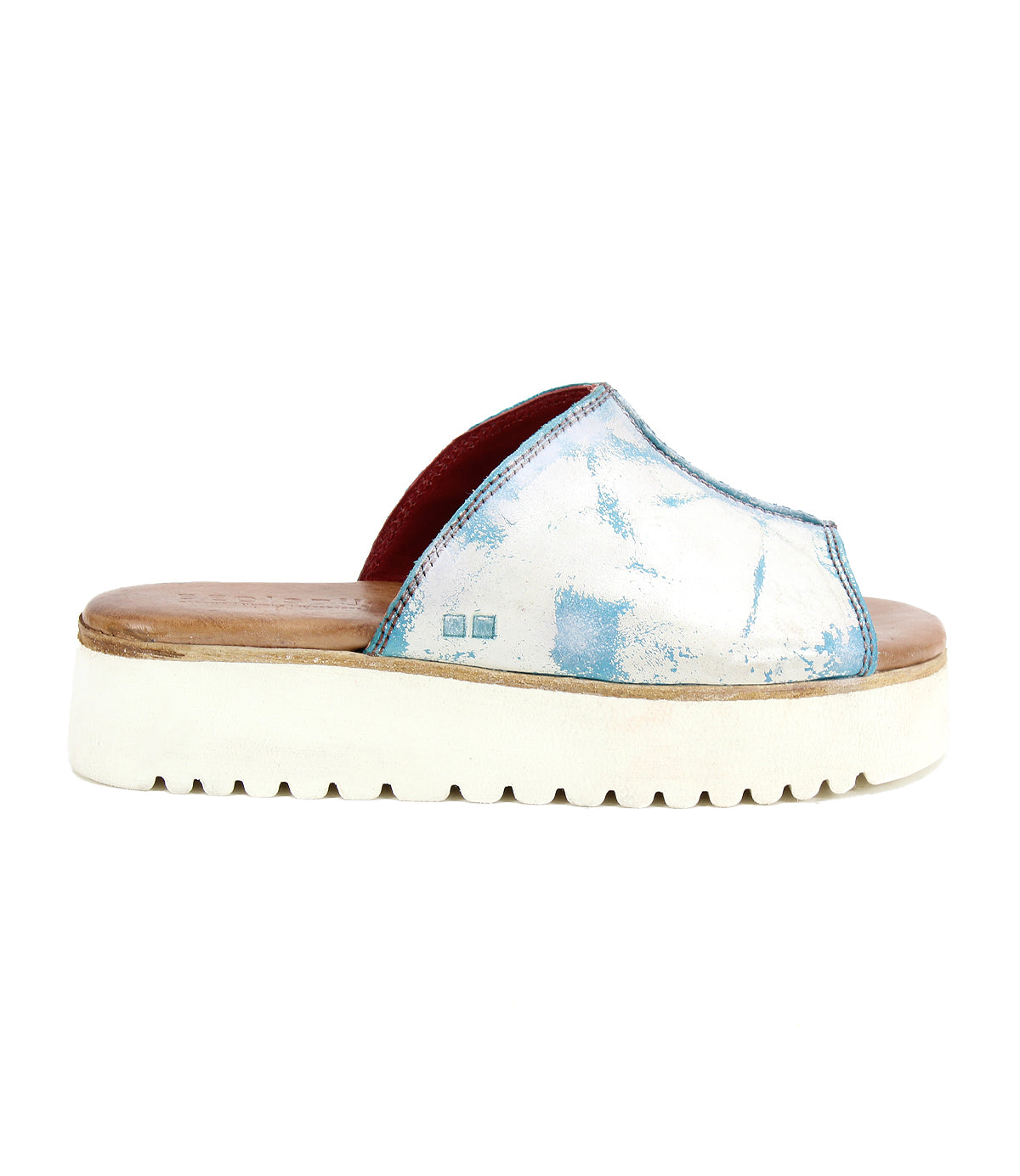 The Bed Stu Fairlee II, a white flatform slide sandal with blue accents, a thick sole, and a leather-lined footbed, is showcased on a white background.