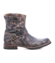 The Bed Stu Fellow boot, a rugged men's leather style in weathered brown with two decorative buckles, rounded toe, and low heel, is shown in profile against a white background.