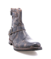 The Bed Stu Fellow is a moto-inspired, distressed brown leather ankle boot with buckled straps and a low heel, shown on a white background.