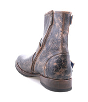 Close-up of the Bed Stu Fellow men’s leather boot with Goodyear welt and side zipper, shown from the back and side to highlight its rugged, distressed finish against a white background.