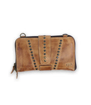 A brown leather wallet called "Flee" with metal rivets and a strap closure, featuring a secure zip closure. The brand label "Bed Stu" is visible.
