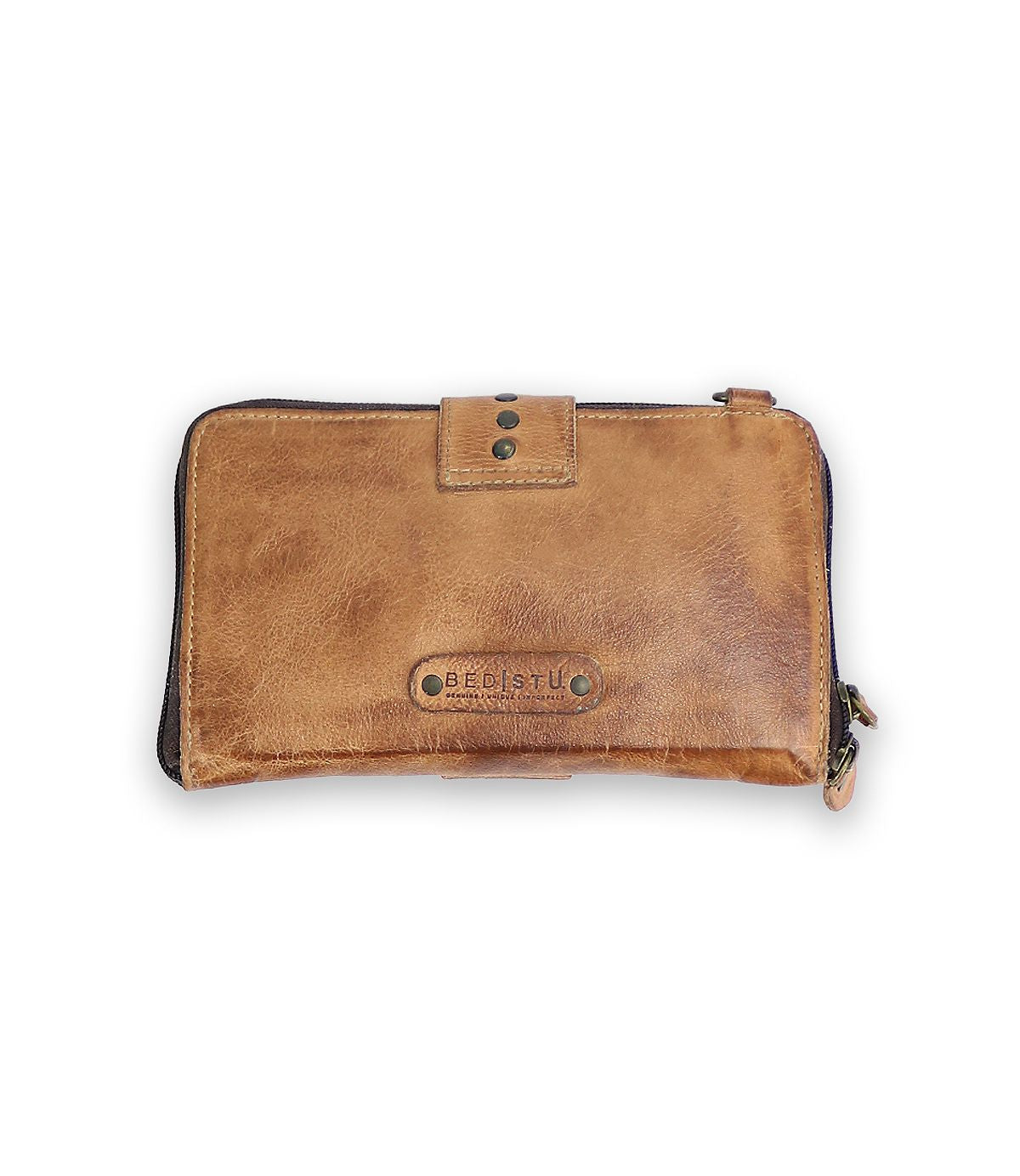 The Flee wallet by Bed Stu is crafted in brown leather, adorned with metal studs, and has the brand name embossed on the front. It features a secure zip closure and snap fastening.