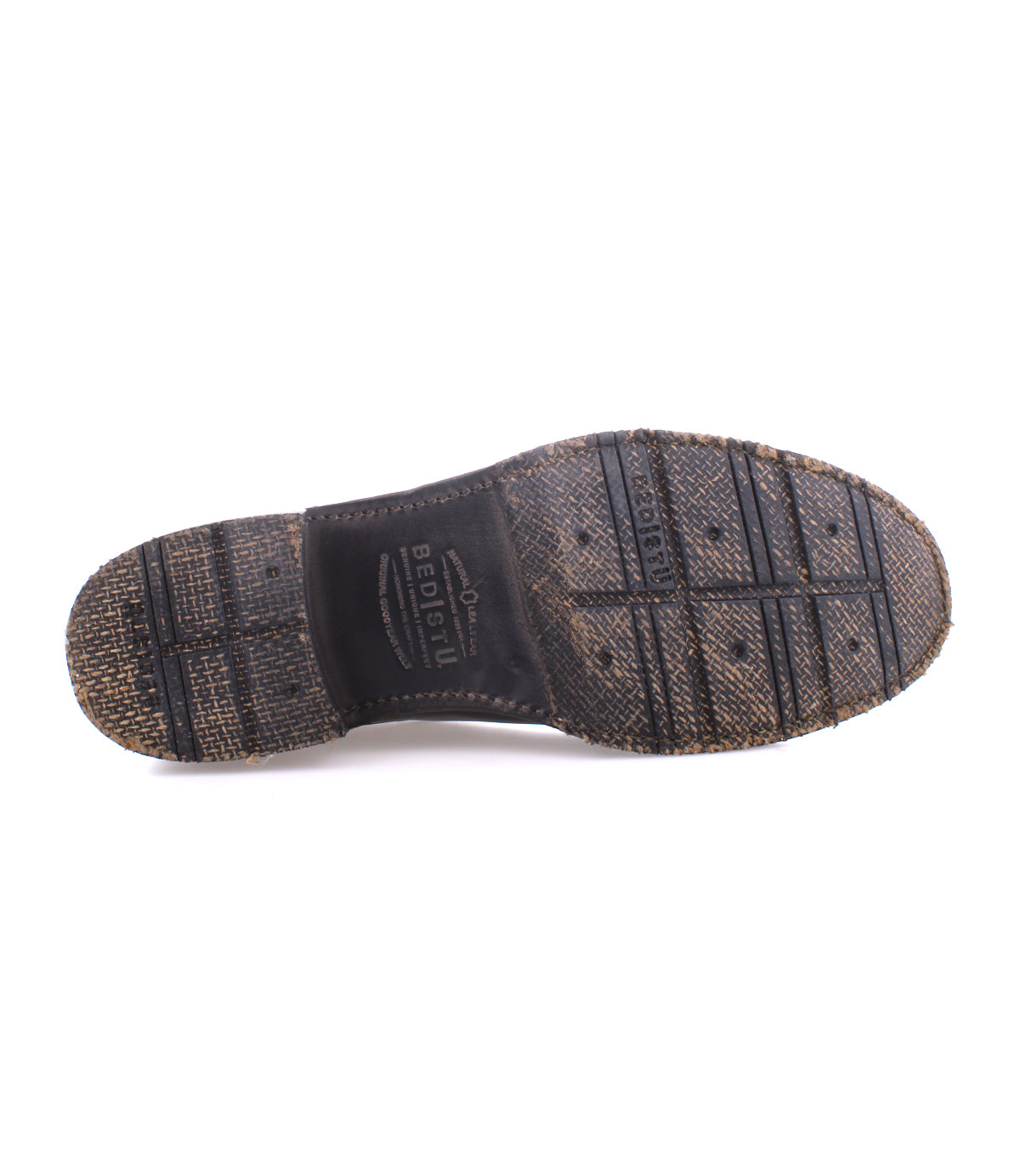 The underside of a worn black shoe sole with visible tread patterns and textured surface reveals the durability of Goodyear welted craftsmanship, echoing the rugged style of moto-inspired men’s leather boots, characteristic of Bed Stu's "Fellow" design.