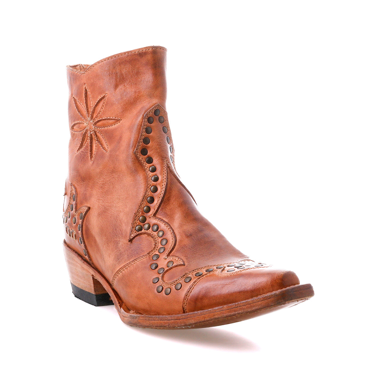 The Bed Stu Frio is a brown leather Western bootie with decorative stitching, floral cutouts, brass studs, a low stacked heel, and a pointed toe, displayed against a white background.