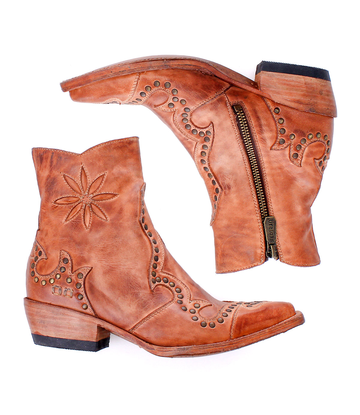 The Frio by Bed Stu: brown leather Western bootie ankle boots featuring decorative stitching, brass studs, side zippers, and low stacked heels, displayed against a white background.