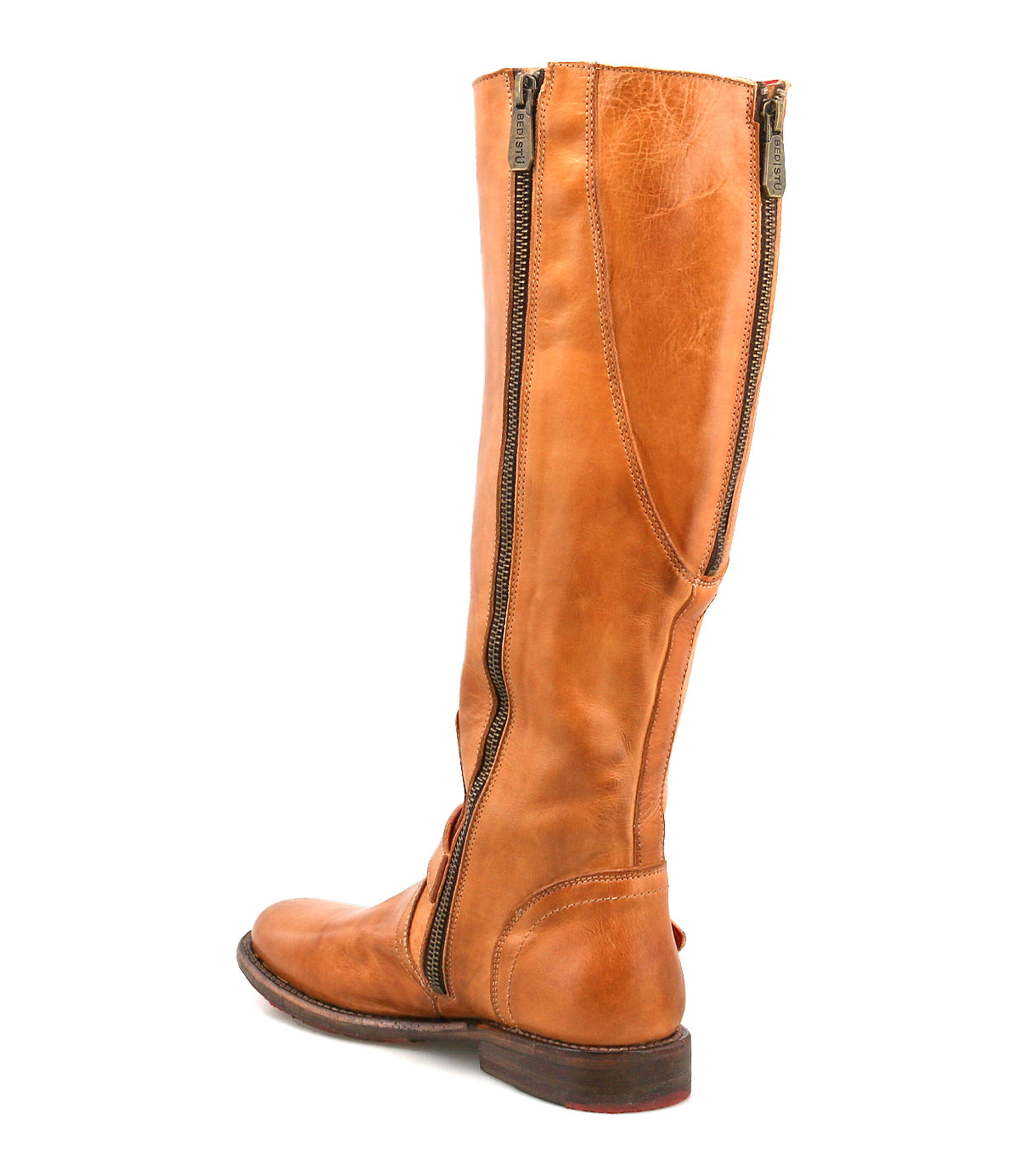 The Bed Stu Glaye is a tan leather knee-high equestrian boot featuring dual side zippers, a vintage buckle detail, and a low heel, displayed at an angle on a white background.