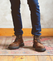 A man in Bed Stu Goer oiled suede leather boots, standing on a rug.