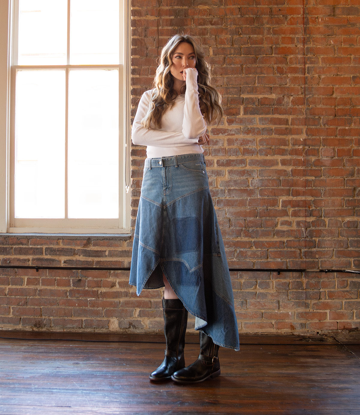 A woman in a denim skirt and Bed Stu Gogo Lug moto-style leather boots.