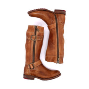 A pair of Bed Stu's Gogo Lug brown leather knee-high boots with side zippers and buckle details, featuring a durable lug outsole, laid flat against a white background.