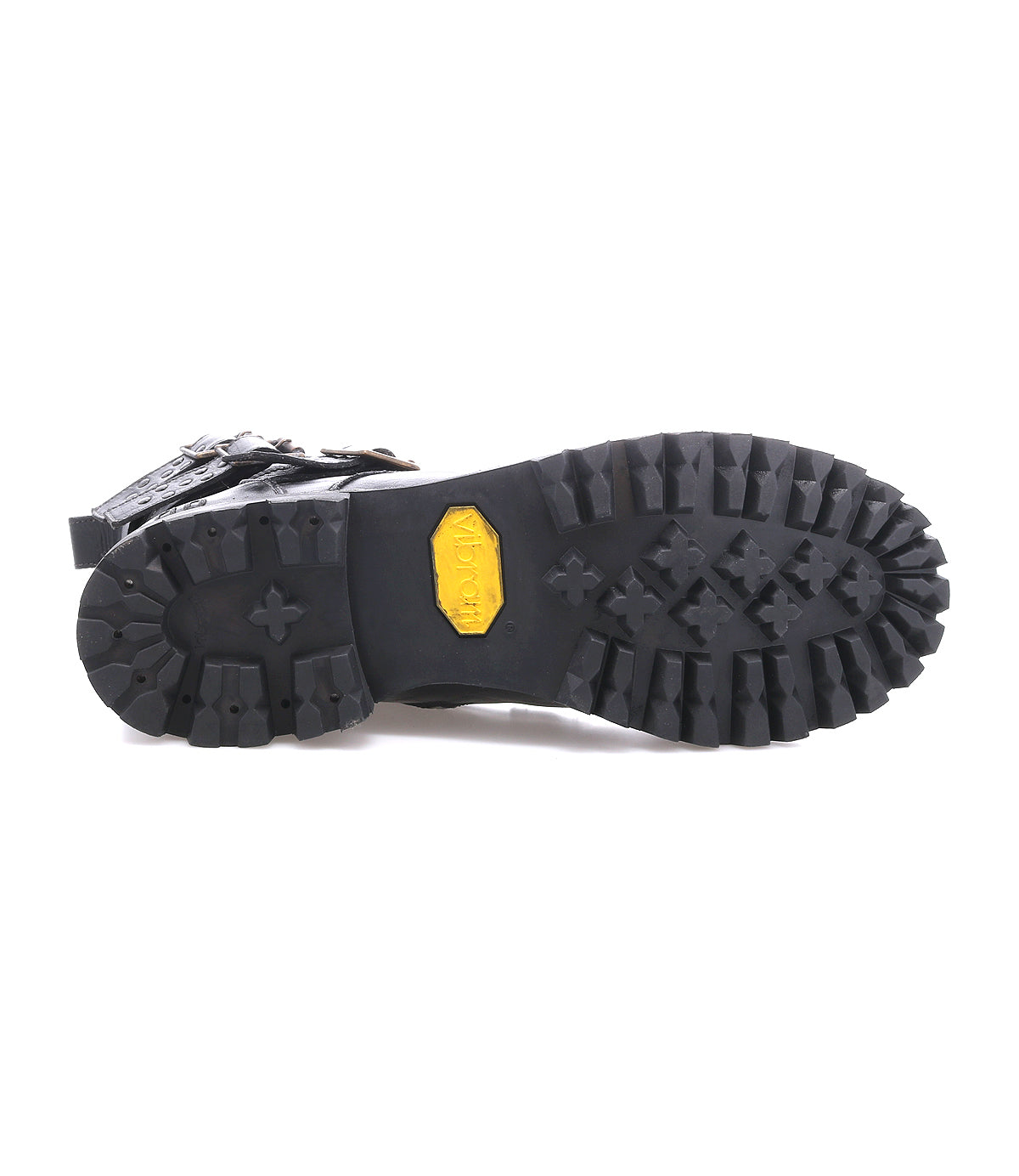 The Grab boot by Bed Stu features a black combat-inspired design with a durable Vibram rubber lug sole. Its deep, rugged treads and central yellow Vibram logo highlight its tough construction.