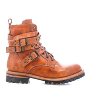 The Bed Stu Grab is a brown leather combat-inspired boot with studded buckle straps, metal accents, a Vibram rubber lug sole, and slight heel, shown from the side on a white background.