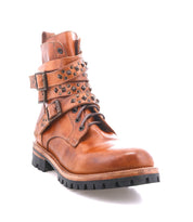 The Bed Stu Grab is a brown leather combat-inspired boot with studded buckle straps, metal studs, and a durable black Vibram lug sole, shown against a white background.