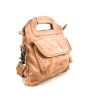 The Bed Stu Greenway is a light brown leather crossbody bag with a front flap pocket, integrated handle, buckle detail, and secure zipper, shown against a plain white background.