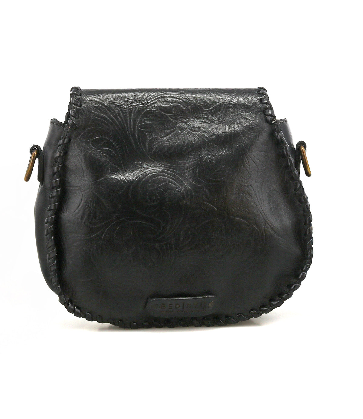 The Bed Stu Half Moon EM is a black saddlebag crossbody purse featuring an embossed foliage pattern, front stitching, metal side hardware, and a chic leather tassel.