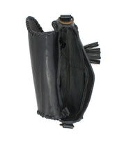 Top view of Bed Stu's Half Moon EM—an empty black leather saddlebag crossbody with visible stitching, an open compartment, side leather tassel detail, and a subtle embossed foliage pattern.