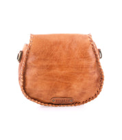 The Bed Stu Half Moon is a small brown leather crossbody purse with visible edge stitching, an adjustable strap, and a front metal logo plate reading "BED|STU.