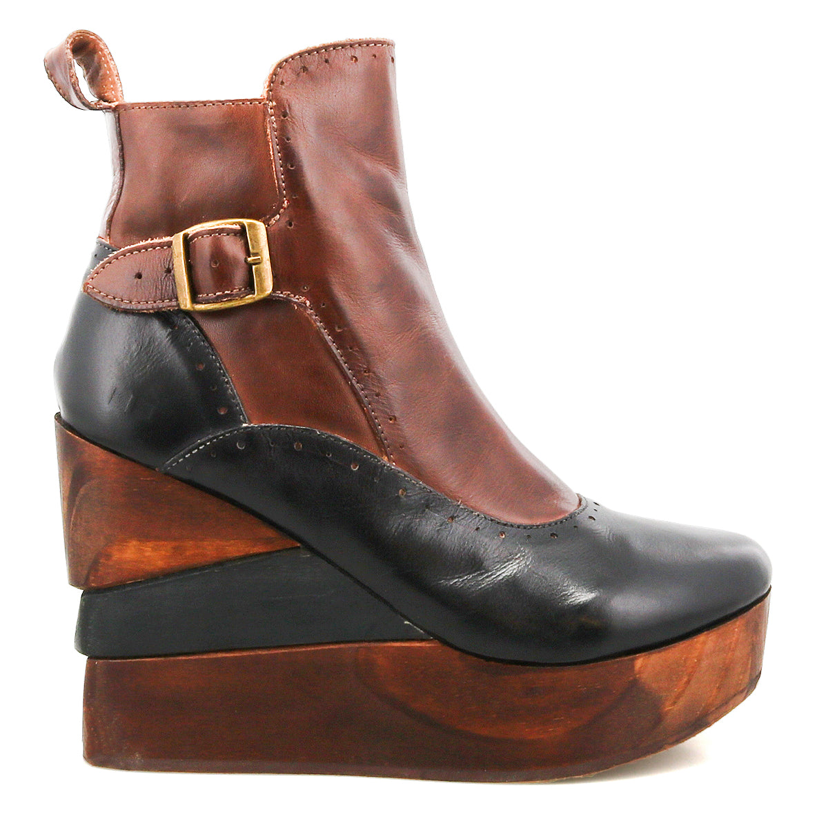 The Bed Stu Harmonious is a two-tone platform wedge ankle boot with a brown upper, black toe, gold buckle, brogue perforations, and a sculptural wood heel.