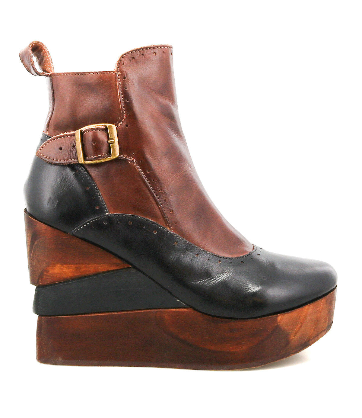 The Bed Stu Harmonious is a two-tone platform wedge ankle boot with a brown upper, black toe, gold buckle, brogue perforations, and a sculptural wood heel.