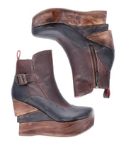 The Bed Stu "Harmonious" boots are brown leather platform wedge ankle boots with sculptural wood soles, leather lining, side zippers, and buckle details, displayed from side and top views on a white background.