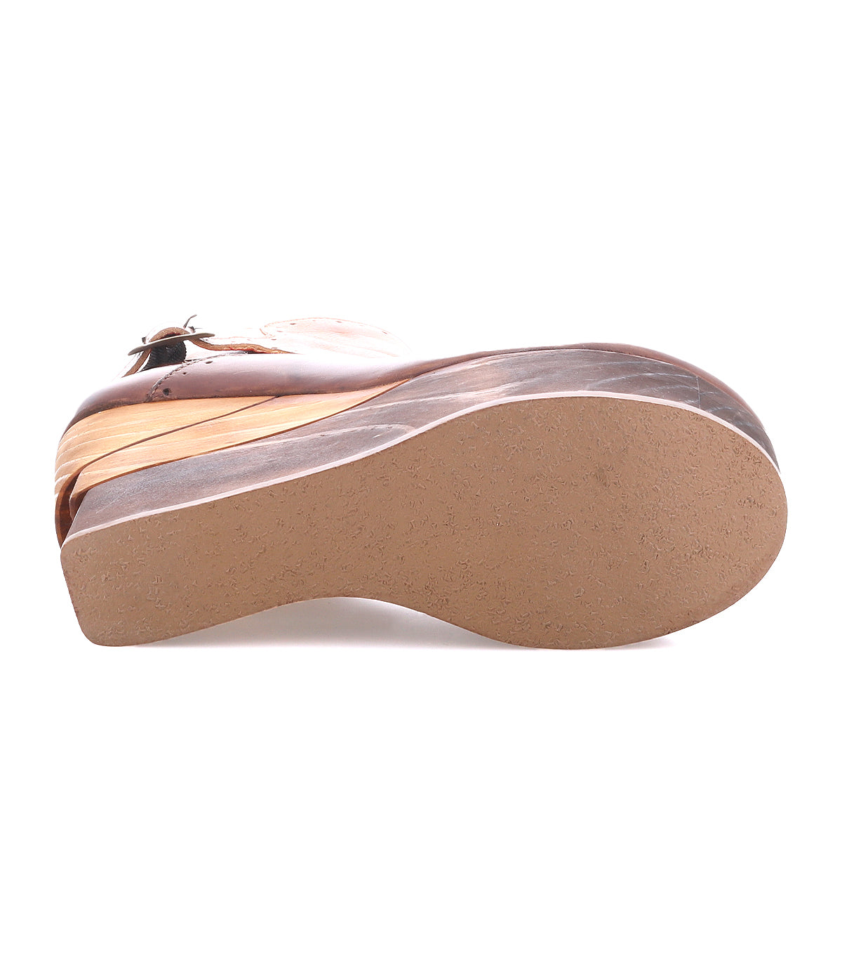 The image shows the sole of the Bed Stu Harmonious brown wedge shoe with a closed toe, sculptural wood platform, leather interior, and buckle strap, photographed against a white background.