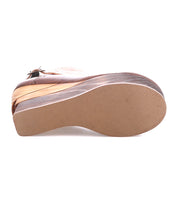 The image shows the sole of the Bed Stu Harmonious brown wedge shoe with a closed toe, sculptural wood platform, leather interior, and buckle strap, photographed against a white background.