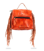 The Bed Stu handbag features orange leather with fringe details, an adjustable strap for versatility, a front zipper pocket, and a short top handle.