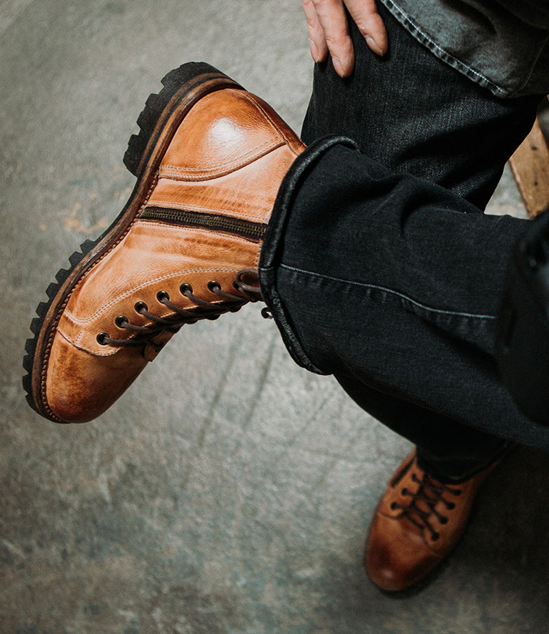 Top shot of crossed legs in black jeans wearing tan leather boots