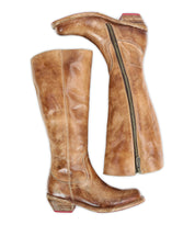 The Bed Stu Humble boots—tall brown leather with side zippers, low stacked wooden heels, and classic design—are shown side by side on a white background.