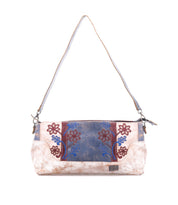 The Bed Stu Hyperbolic is a rectangular bohemian leather shoulder bag featuring beige, blue, and maroon floral embroidery, a brown strap, and a small metal logo plate on the front.